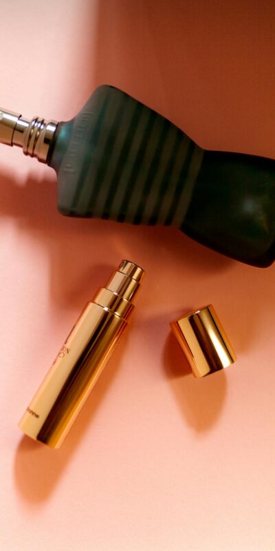 Elegant arrangement of luxury perfume bottles captured in a flat lay style on a peach background.