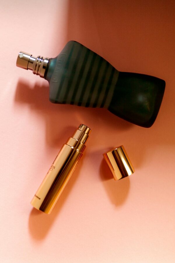 Elegant arrangement of luxury perfume bottles captured in a flat lay style on a peach background.