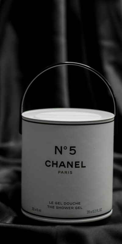 Minimalist black and white image of Chanel No. 5 shower gel against a fabric background.