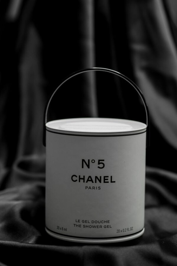 Minimalist black and white image of Chanel No. 5 shower gel against a fabric background.