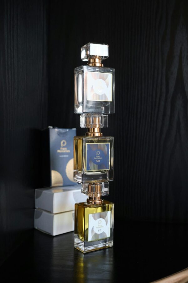 Stylish composition of stacked perfume bottles with sleek black backdrop for elegant display.